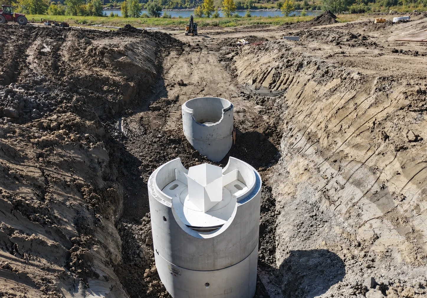 Oil/grit separator installation in an excavated trench beside a river